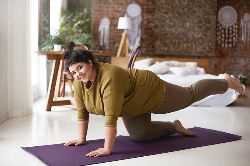 Eine füllige Frau macht eine Yogapose